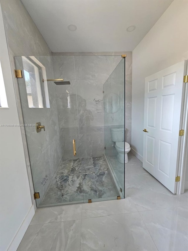 full bath featuring marble look tile flooring, a shower stall, toilet, and baseboards
