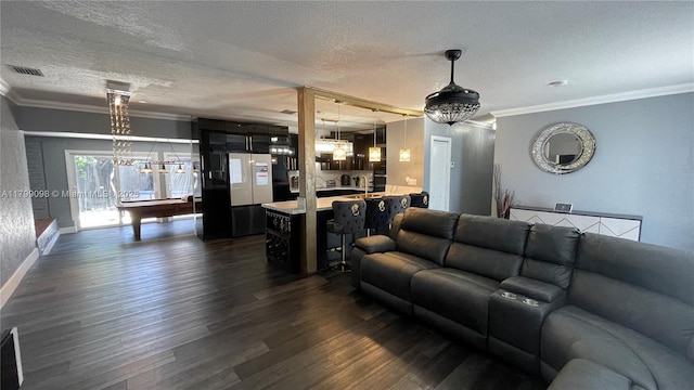 living room featuring a textured ceiling, crown molding, dark wood finished floors, and baseboards