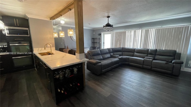 living area featuring crown molding, dark wood finished floors, and a textured ceiling
