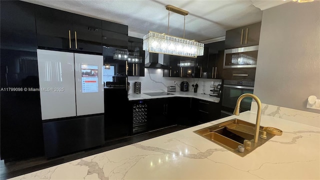 kitchen featuring dark cabinets, wall chimney range hood, oven, and stainless steel microwave