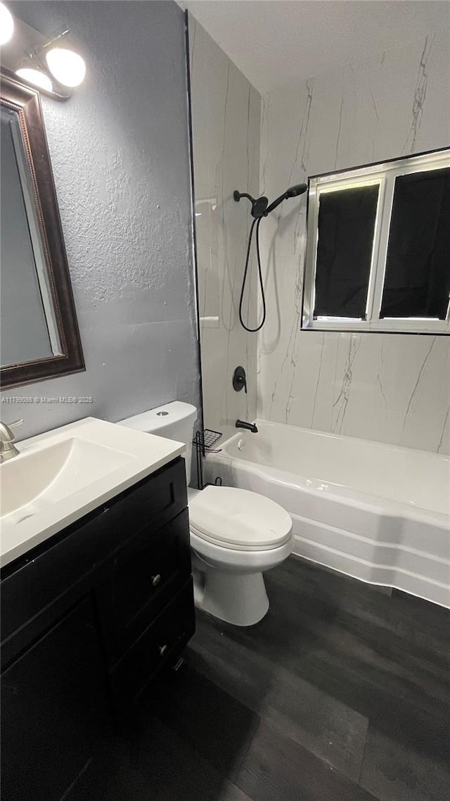 bathroom with tub / shower combination, wood finished floors, vanity, and toilet