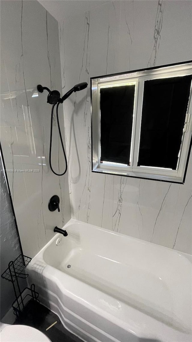 bathroom featuring shower / bathtub combination and toilet