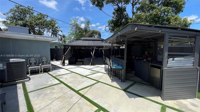 view of patio featuring a gazebo, cooling unit, and fence
