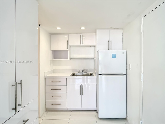 555 NE 15th St Unit 502, Miami, FL 33132 - kitchen featuring freestanding refrigerator, a sink, white cabinets, light countertops, and light tile patterned flooring