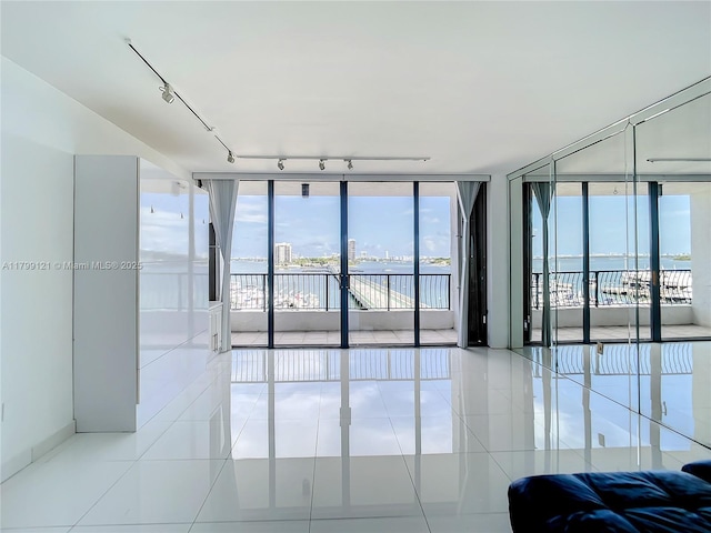 555 NE 15th St Unit 502, Miami, FL 33132 - tiled empty room featuring floor to ceiling windows, a water view, and track lighting