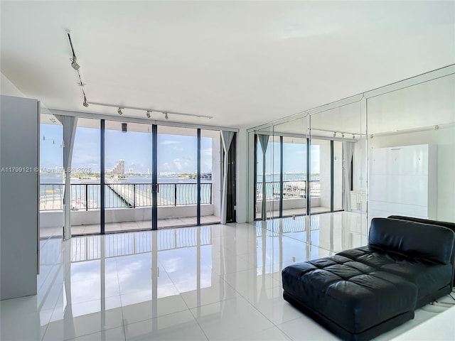 555 NE 15th St Unit 502, Miami, FL 33132 - living area with expansive windows, tile patterned floors, rail lighting, healthy amount of natural light, and a water view