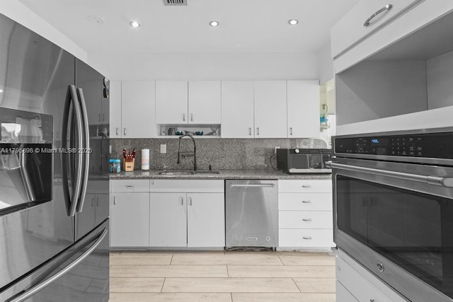 5715 Bayberry Ln, Tamarac, FL 33319 - kitchen featuring appliances with stainless steel finishes, a sink, white cabinetry, recessed lighting, and backsplash
