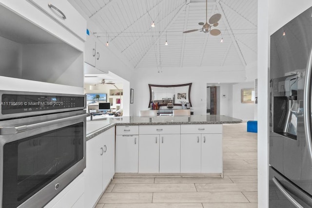 5715 Bayberry Ln, Tamarac, FL 33319 - kitchen with stainless steel appliances, a ceiling fan, a peninsula, white cabinetry, and light wood-type flooring