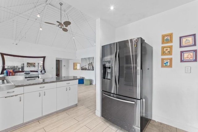 5715 Bayberry Ln, Tamarac, FL 33319 - kitchen with stainless steel fridge, white cabinets, dark stone counters, light wood-style flooring, and a ceiling fan