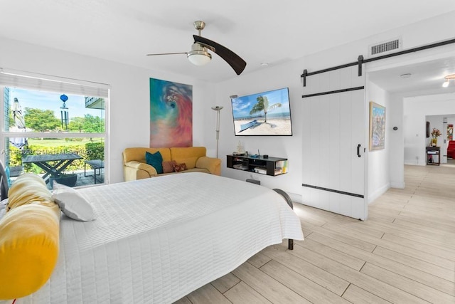 5715 Bayberry Ln, Tamarac, FL 33319 - bedroom with a barn door, light wood-type flooring, and a ceiling fan