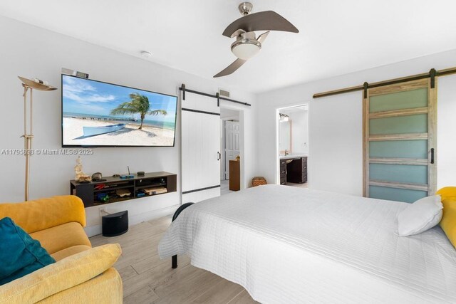 5715 Bayberry Ln, Tamarac, FL 33319 - bedroom featuring a barn door, wood finished floors, ceiling fan, and ensuite bathroom