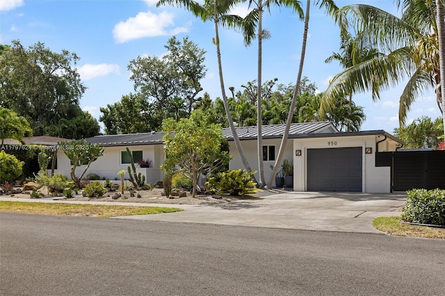 950 NE 88th St, Miami, FL 33138 - view of front of house with an attached garage, concrete driveway, a standing seam roof, metal roof, and stucco siding