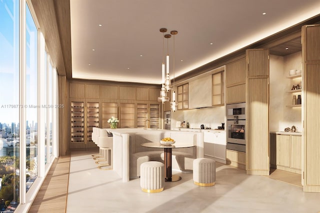 1671 Collins Ave Unit 15A, Miami Beach, FL 33139 - kitchen featuring oven, light countertops, hanging light fixtures, and a kitchen island with sink