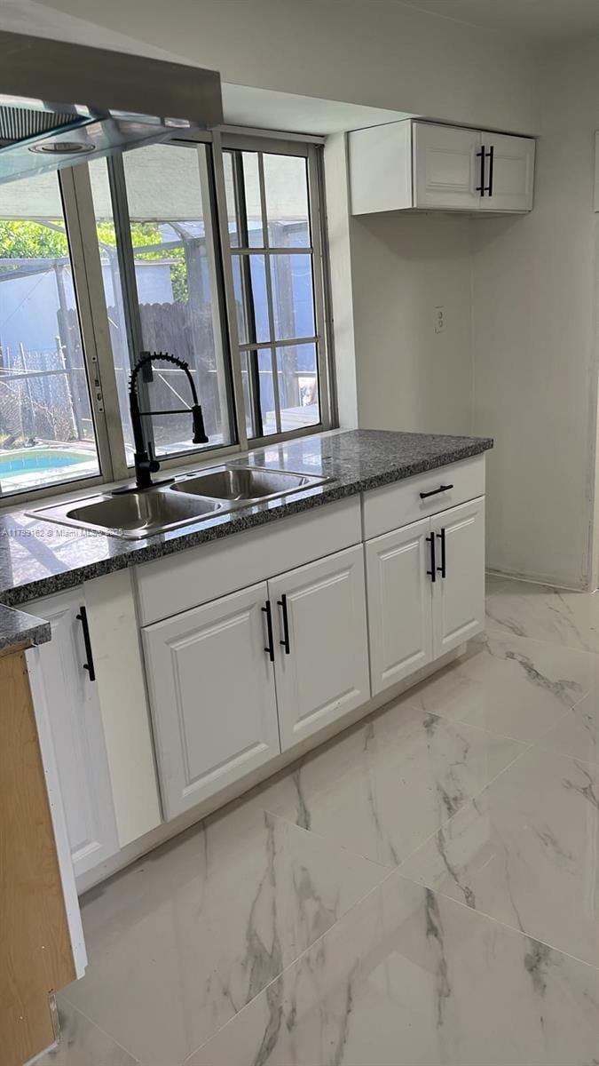 6704 Emerald Lake Dr, Miramar, FL 33023 - kitchen with a sink, white cabinetry, light marble finish flooring, and dark stone countertops