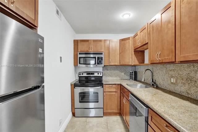2840 NE 14th St Cswy Unit 408A, Pompano Beach, FL 33062 - kitchen featuring appliances with stainless steel finishes, a sink, light tile patterned floors, and tasteful backsplash