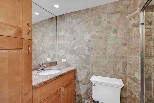 2840 NE 14th St Cswy Unit 408A, Pompano Beach, FL 33062 - bathroom featuring tile walls, toilet, vanity, and recessed lighting
