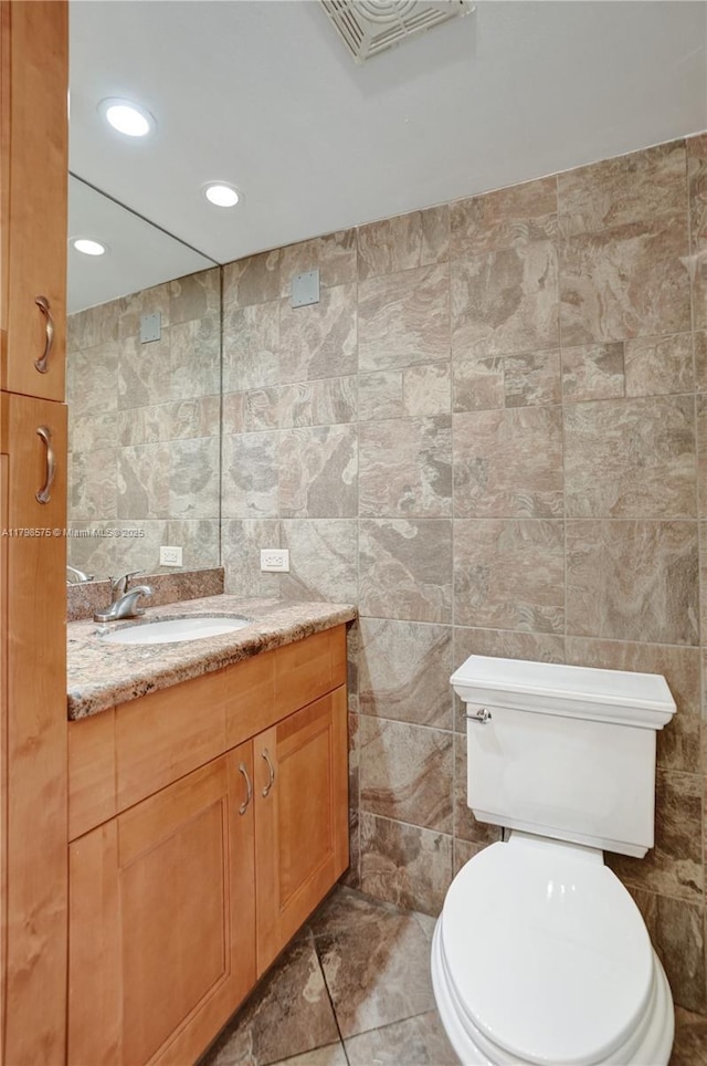 2840 NE 14th St Cswy Unit 408A, Pompano Beach, FL 33062 - bathroom with tile walls, vanity, toilet, and recessed lighting