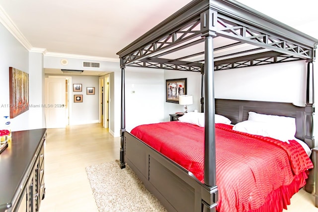 bedroom featuring ornamental molding and wood finished floors