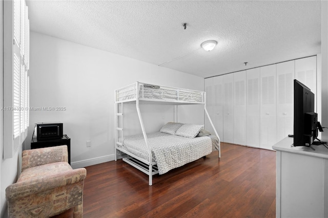 665 NE 195th St Unit 223, Miami, FL 33179 - bedroom with wood finished floors, multiple windows, a textured ceiling, and baseboards