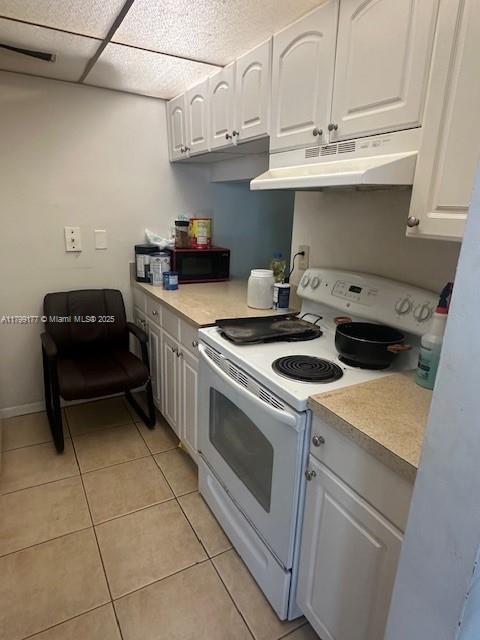 1900 N Congress Ave Unit 305, West Palm Beach, FL 33401 - kitchen with white range with electric stovetop, under cabinet range hood, white cabinets, and light countertops
