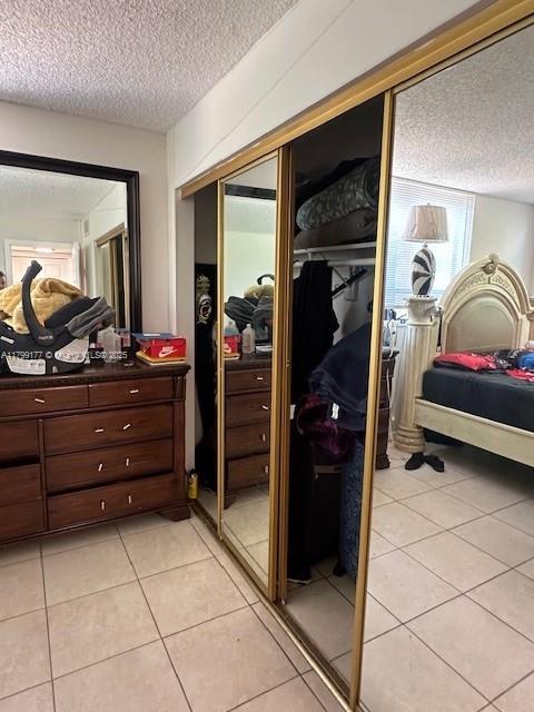 1900 N Congress Ave Unit 305, West Palm Beach, FL 33401 - bedroom featuring a textured ceiling, light tile patterned flooring, and a closet