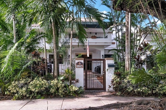 1226 Cordova St, Coral Gables, FL 33134 - view of front of home with a balcony, a fenced front yard, a gate, and stucco siding