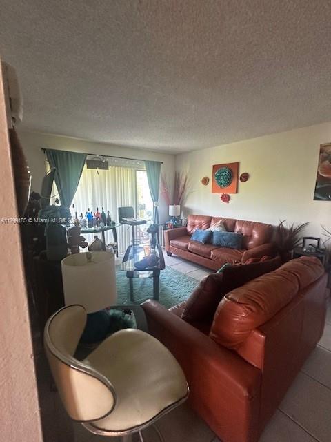1820 N Congress Ave Unit 405, West Palm Beach, FL 33401 - tiled living room with a textured ceiling