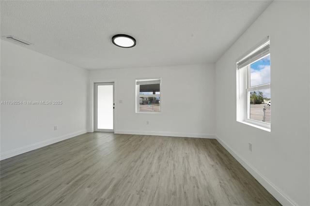 2571 NW 139th St, Opa-Locka, FL 33054 - empty room featuring wood finished floors, baseboards, and a textured ceiling