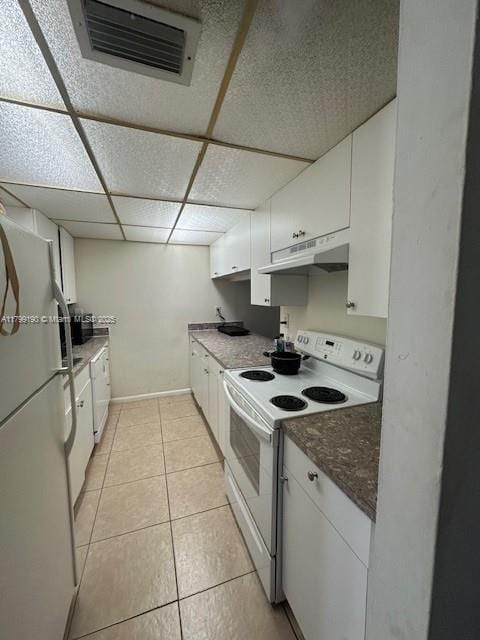 2000 N Congress Ave Unit 411, West Palm Beach, FL 33401 - kitchen with white appliances, under cabinet range hood, white cabinets, light tile patterned floors, and a paneled ceiling