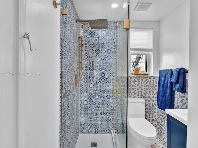 729 85th St, Miami Beach, FL 33141 - full bathroom featuring tile walls, toilet, a shower stall, vanity, and a wainscoted wall