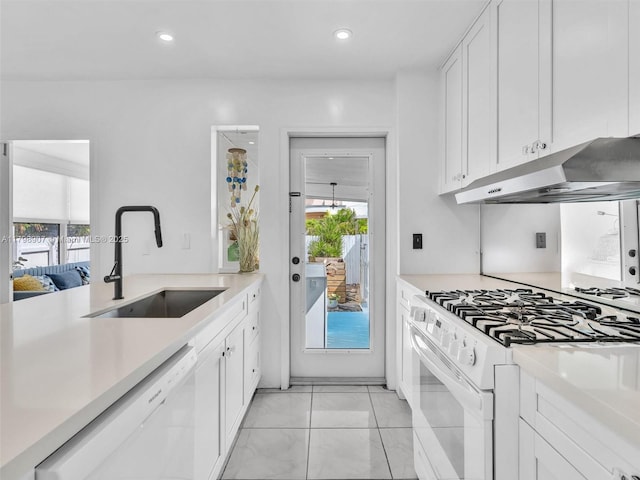 729 85th St, Miami Beach, FL 33141 - kitchen with white appliances, a sink, under cabinet range hood, light countertops, and white cabinetry