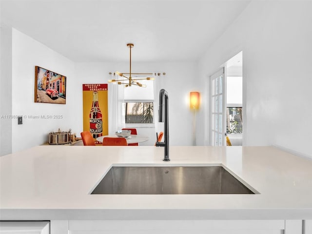 729 85th St, Miami Beach, FL 33141 - kitchen with a sink, a chandelier, light countertops, and hanging light fixtures
