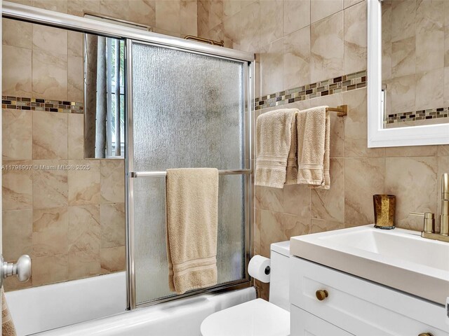 729 85th St, Miami Beach, FL 33141 - bathroom with combined bath / shower with glass door, tile walls, toilet, and vanity