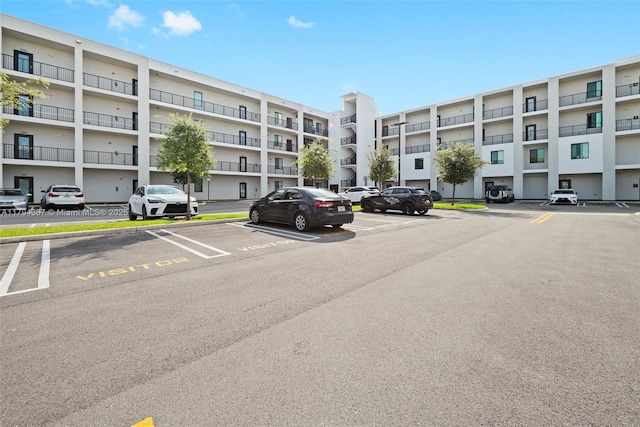 view of apartment building / complex with uncovered parking