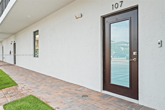 view of exterior entry with stucco siding
