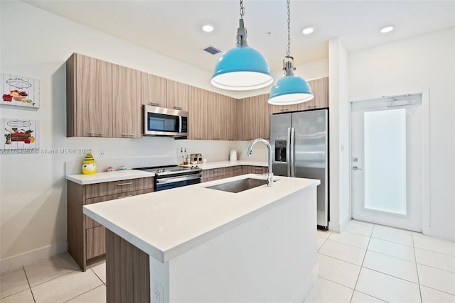 kitchen with appliances with stainless steel finishes, a sink, modern cabinets, light tile patterned floors, and light countertops