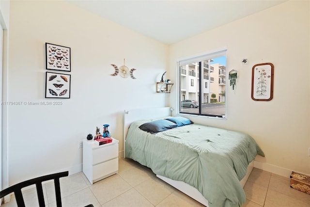 bedroom with tile patterned floors and baseboards
