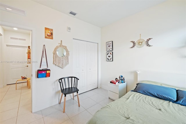 bedroom featuring light tile patterned floors, a closet, and baseboards