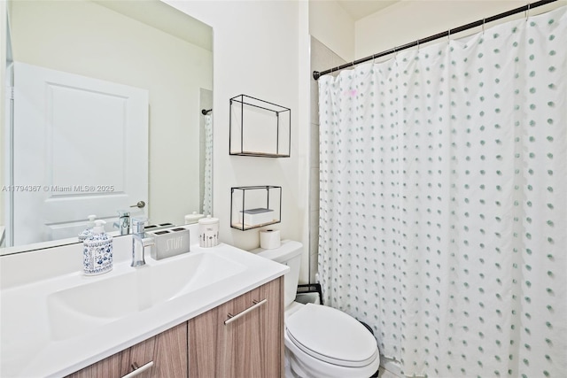 bathroom featuring toilet, vanity, and curtained shower