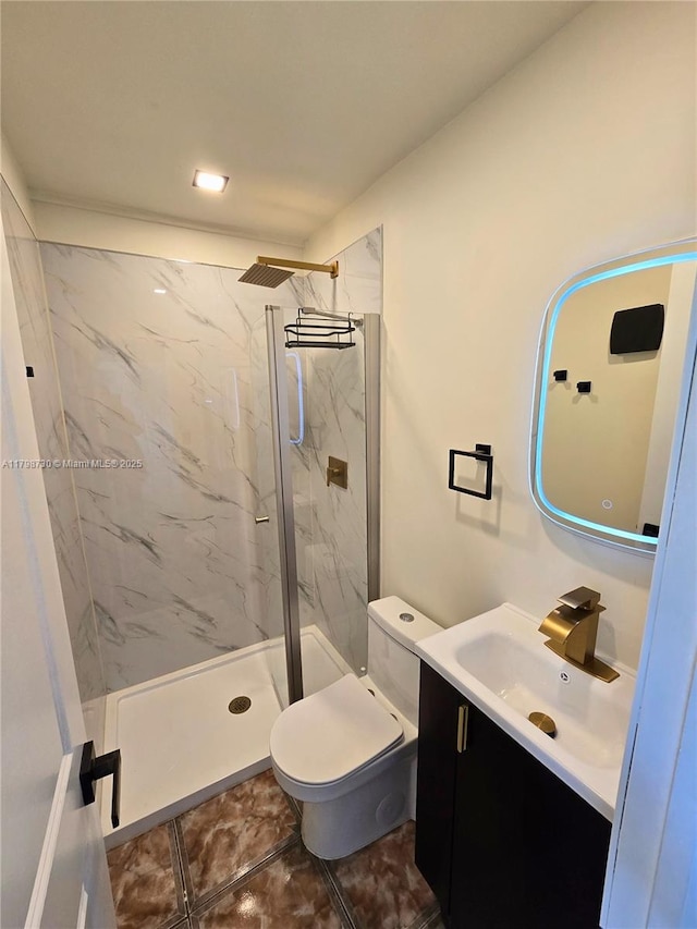 bathroom featuring a marble finish shower, toilet, and vanity