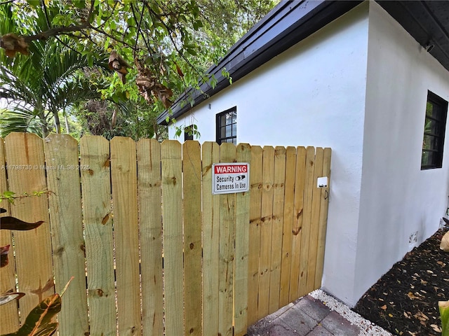 view of property exterior featuring stucco siding and fence