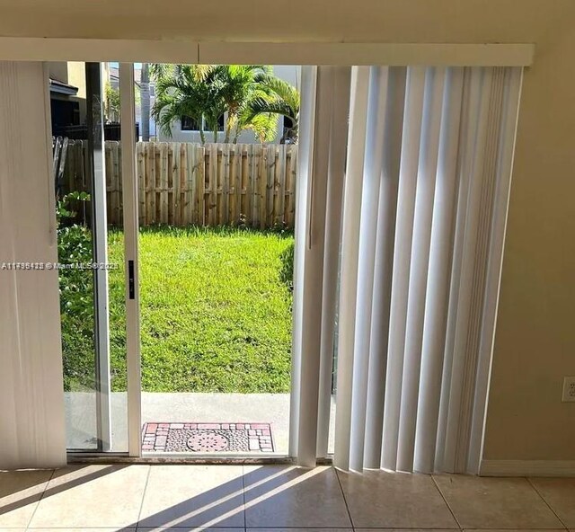 20441 NW 15th Ave Unit 8, Miami Gardens, FL 33169 - doorway featuring tile patterned flooring and baseboards