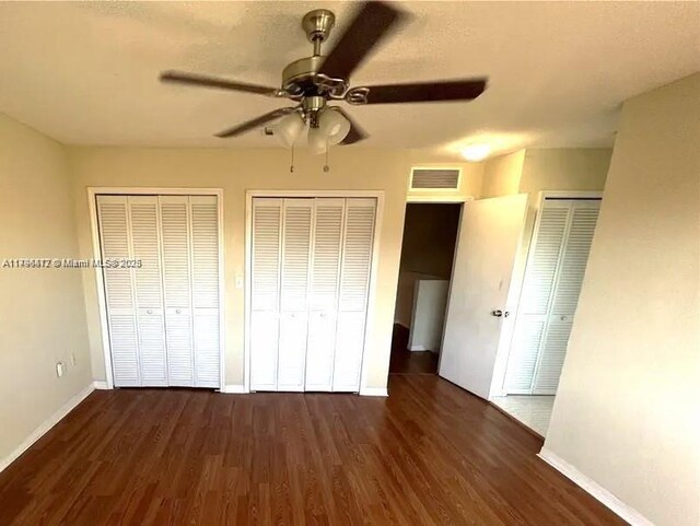 20441 NW 15th Ave Unit 8, Miami Gardens, FL 33169 - unfurnished bedroom with multiple closets, wood finished floors, baseboards, and ceiling fan