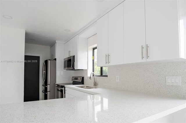 17940 NW 13th Ct, Miami Gardens, FL 33169 - kitchen featuring stainless steel appliances, a sink, decorative backsplash, and white cabinetry