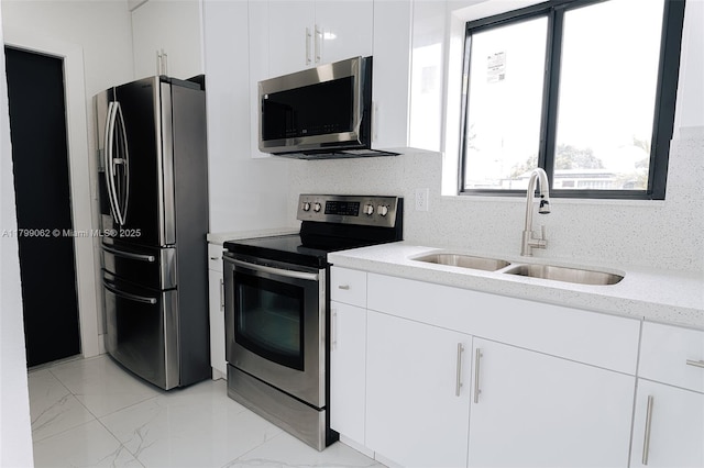 17940 NW 13th Ct, Miami Gardens, FL 33169 - kitchen featuring stainless steel appliances, a sink, white cabinets, light marble finish flooring, and light stone counters