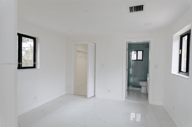 17940 NW 13th Ct, Miami Gardens, FL 33169 - unfurnished bedroom with baseboards, light marble finish floors, multiple windows, and ensuite bathroom