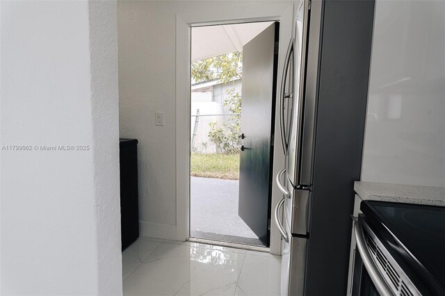 17940 NW 13th Ct, Miami Gardens, FL 33169 - doorway to outside featuring light marble finish floors, a textured wall, and baseboards