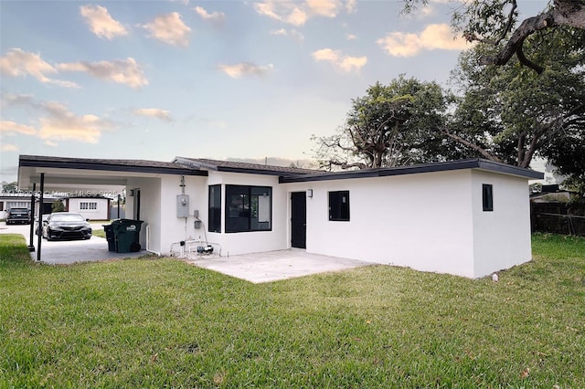 17940 NW 13th Ct, Miami Gardens, FL 33169 - rear view of property featuring stucco siding, a carport, and a lawn
