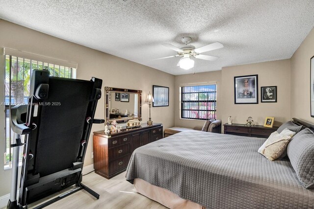 1930 W Oak Knoll Cir, Davie, FL 33324 - bedroom with light wood-type flooring, a ceiling fan, baseboards, and a textured ceiling