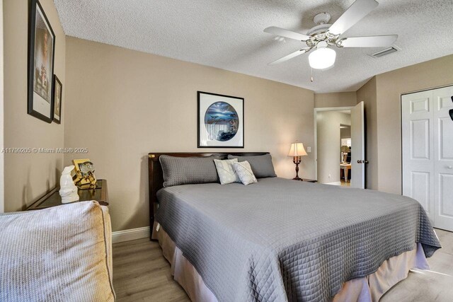 1930 W Oak Knoll Cir, Davie, FL 33324 - bedroom featuring a textured ceiling, a ceiling fan, baseboards, a closet, and light wood-style flooring